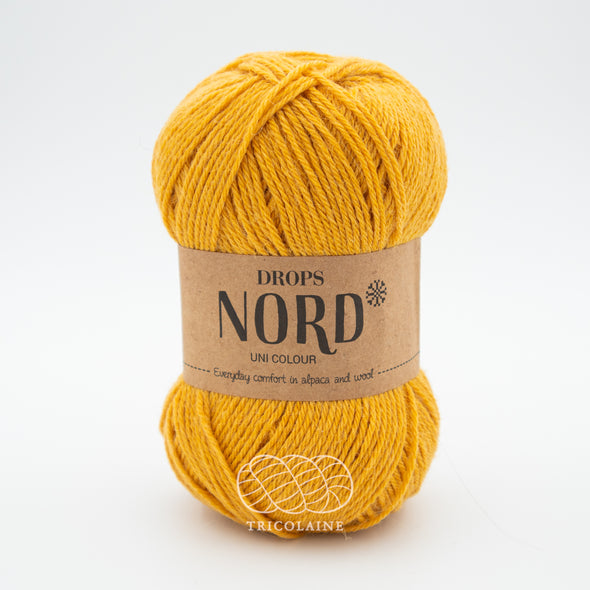 Drops Nord, un doux mélange de laine péruvienne et d'alpaga.  De calibre Sport, cette fibre se tricote avec une aiguille 3 mm.  Coloris Jaune d'or, un joli jaune doré pas tout à fait moutarde.