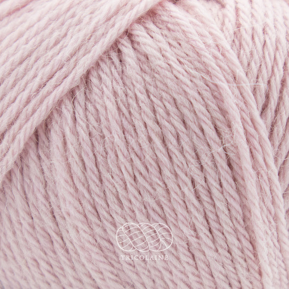 Drops Nord, un doux mélange de laine péruvienne et d'alpaga.  De calibre Sport, cette fibre se tricote avec une aiguille 3 mm.  Coloris Rose poudre, un rose très pâle presque chair.
