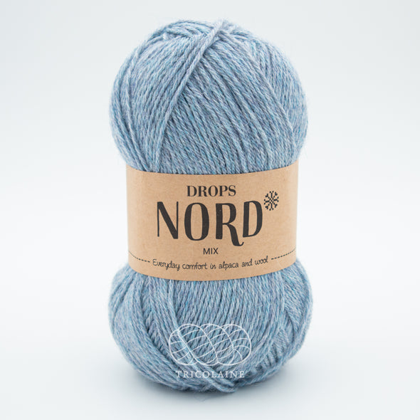 Drops Nord, un doux mélange de laine péruvienne et d'alpaga.  De calibre Sport, cette fibre se tricote avec une aiguille 3 mm.  Coloris Brouillard, un coloris qui joue avec les tonalités de bleu pâle.