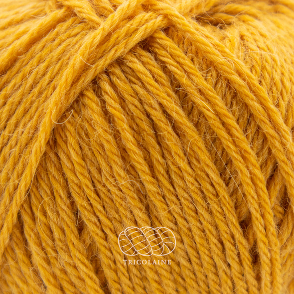 Drops Nord, un doux mélange de laine péruvienne et d'alpaga.  De calibre Sport, cette fibre se tricote avec une aiguille 3 mm.  Coloris Jaune d'or, un joli jaune doré pas tout à fait moutarde.