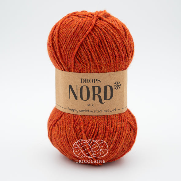 Drops Nord, un doux mélange de laine péruvienne et d'alpaga.  De calibre Sport, cette fibre se tricote avec une aiguille 3 mm.  Coloris Rouille, un orangé mix avec des variations de teintes allant vers le orange brûlé.