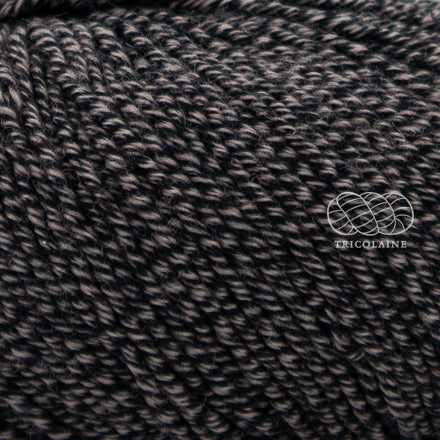 Merino 120 de Lang Yarns, une laine de mérinos fine, extradouce et traitée supewash. De calibre DK, elle se tricote avec des aiguilles 3.5 à 4 mm. Coloris Black Stone, un chiné qui mélange deux teintes; un noir et un beige brun.  Le coloris rappelle le jaspe ou une pierre.