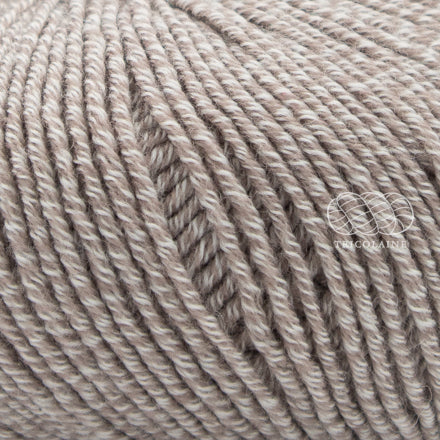 Merino 120 de Lang Yarns, une laine de mérinos fine, extradouce et traitée supewash. De calibre DK, elle se tricote avec des aiguilles 3.5 à 4 mm. Coloris Sand Dust, un chiné mélangeant des brins de ivoire et un grège.  