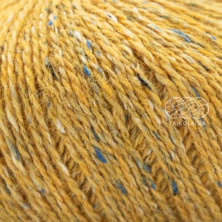Rowan Felted Tweed, une fibre de calibre DK constituée de laine, alpaga et viscose avec effet tweed. Coloris Mineral, un jaune maïs.