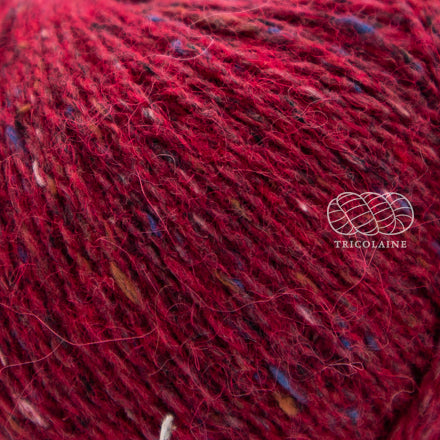 Rowan Felted Tweed, une fibre de calibre DK constituée de laine, alpaga et viscose avec effet tweed. Coloris Rage, un rouge vif qui tire vers le Bordeaux.